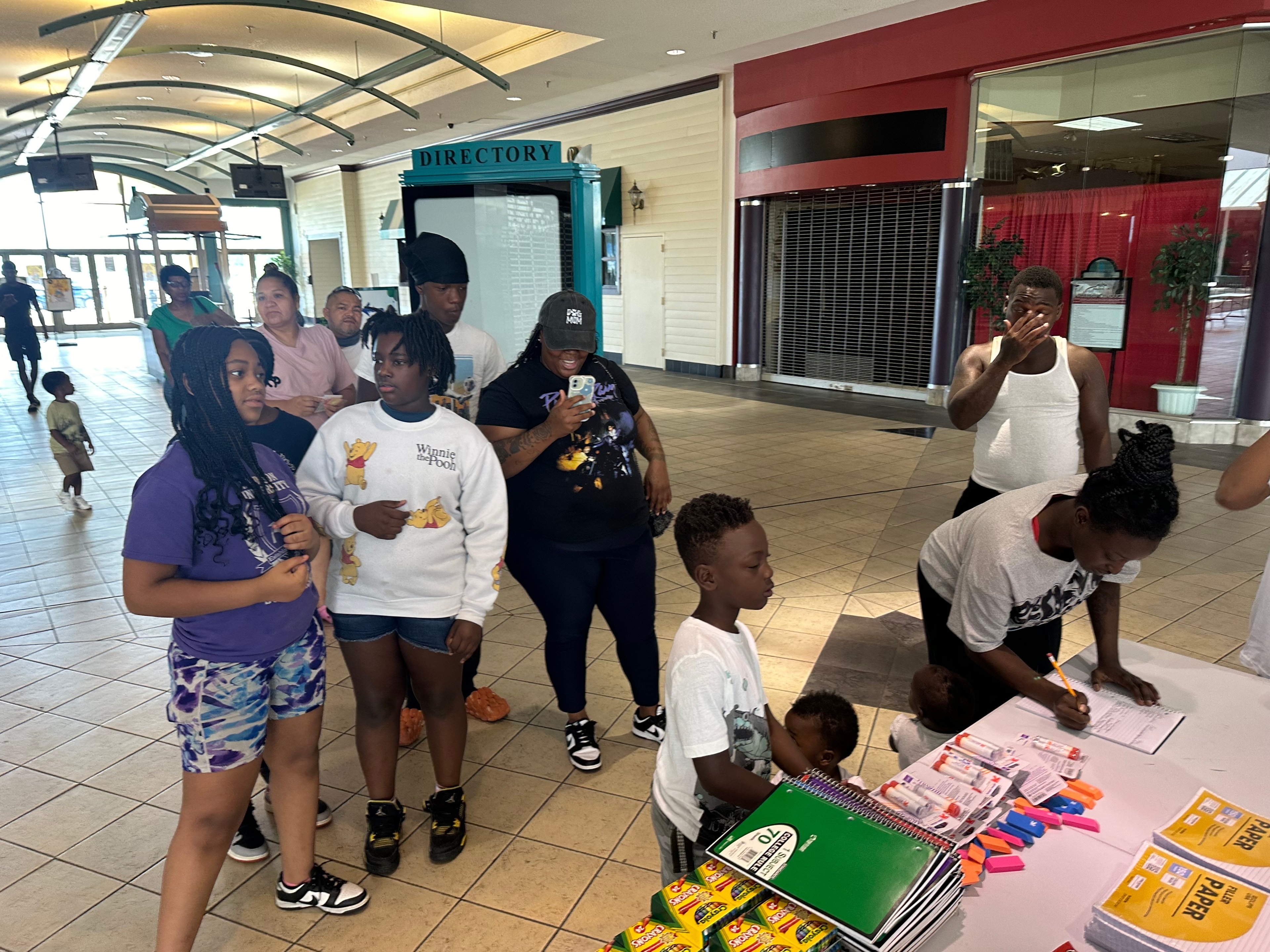 Families lining up to receive school supplies at the backpack giveaway